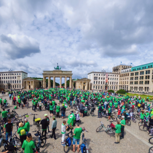 Blick auf das Brandenburger Tor mit Teilnehmenden der Sternfahrt davor.